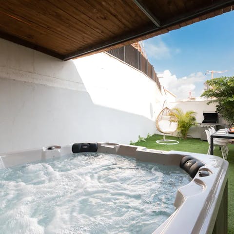 Get the eight-seater hot tub bubbling beneath the pergola in the evening