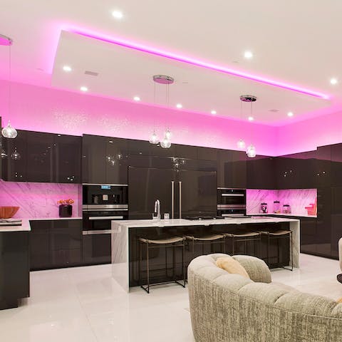 Prepare some nibbles and cocktails under the pink lighting in the chef's kitchen