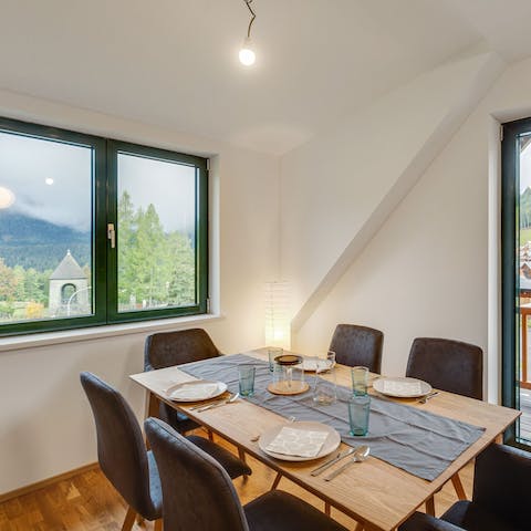 Spend meals together around the wooden dining table, accompanied by forest views