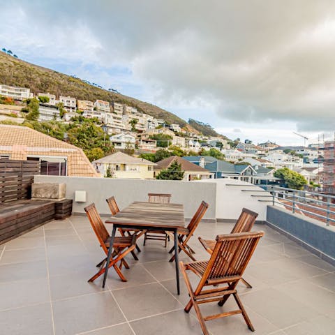 Share a bottle of wine from the vineyards on the cute wooden terrace table 