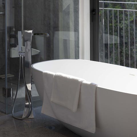Sink back into steamy water in the elegant freestanding bathtub