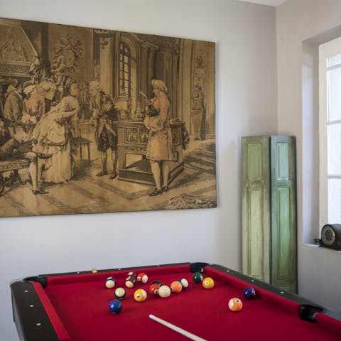 Play a competitive game of pool under the watchful eye of  period decor