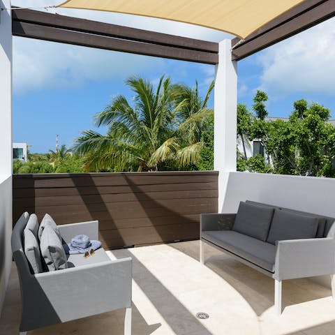 Relax on the covered balcony and watch the palm trees sway while you sip your drink