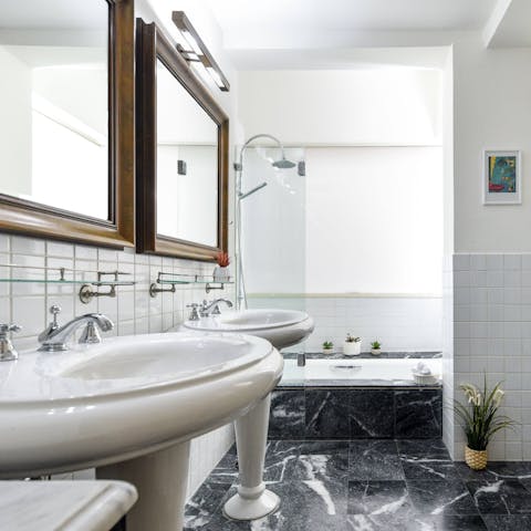 Unwind in your luxury marbled bathroom, boasting a rain shower over the bathtub