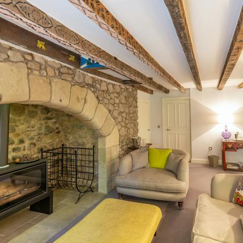 Get cosy by the warmth of the wood-burning stove in the living room