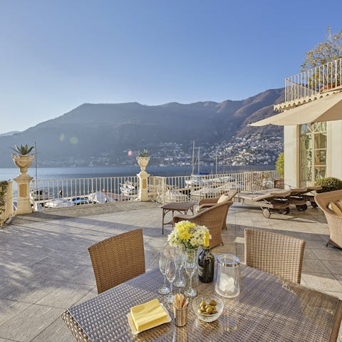 Admire the rugged hills cascading down to the lakeside from the sun-drenched terrace