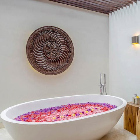 Bath in the freestanding bath filled with petals after a relaxing massage