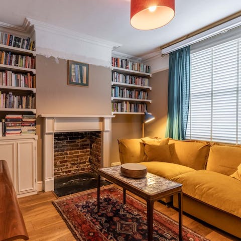Select a book and relax on the mustard velvet sofa