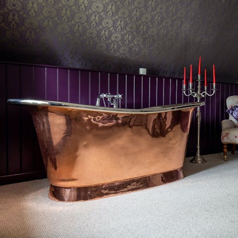 Sink into the luxurious copper bathtub by the bed for a cosy evening