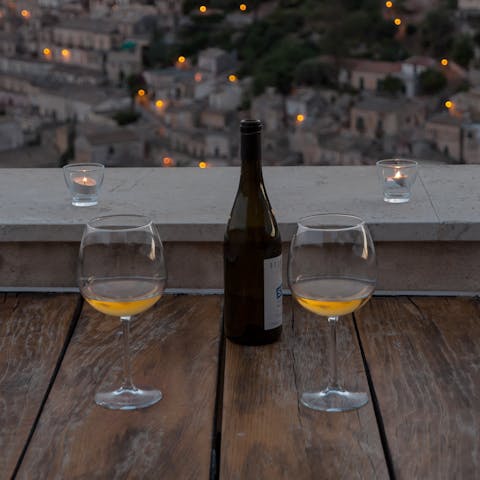 Sip on malvasia wine while watching the lights of Modica twinkle at night