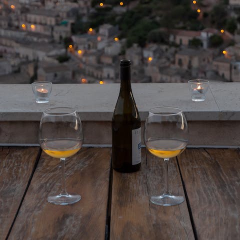 Sip on malvasia wine while watching the lights of Modica twinkle at night