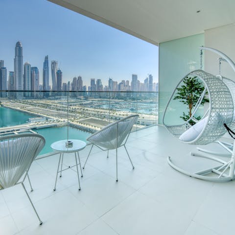 Watch the sun set behind the iconic skyline on your private balcony