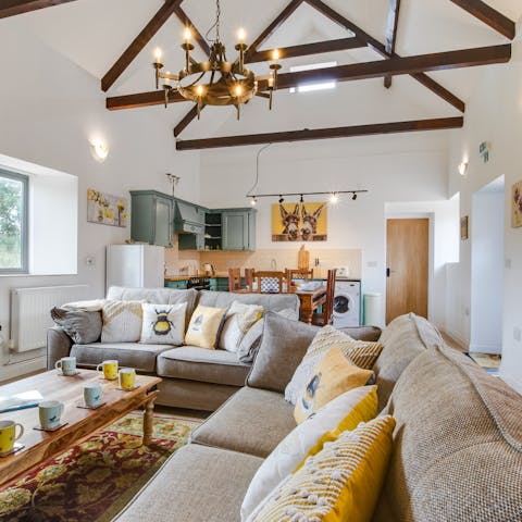 Relax in the open plan living space with its original beams and vaulted ceiling