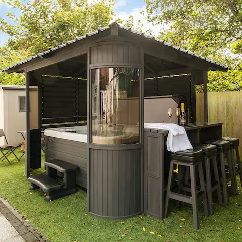 Sit out in the covered hot tub with a glass of something fizzy to hand