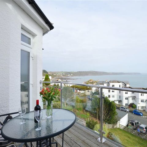 Enjoy a glass of wine on the bedroom's balcony as the sun sets over the water