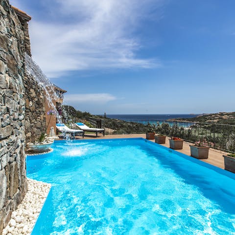 Stay cool under a refreshing waterfall in this pool, as you admire the brilliant sea views