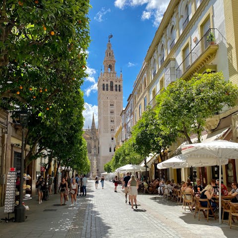 Wander Seville's atmospheric streets towards famous La Giralda 