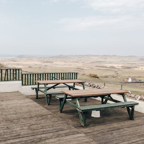 Dine out on the deck with a view for miles across the rugged land to the sea