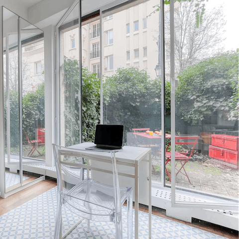 Work at the little desk, well-lit by floor-to-ceiling windows