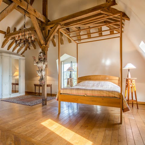 Exposed beams and a four poster bed offer a contemporary take on antique furnishings