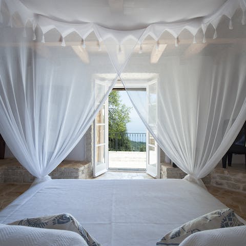 Wake up to stunning sea vistas from the canopied bed