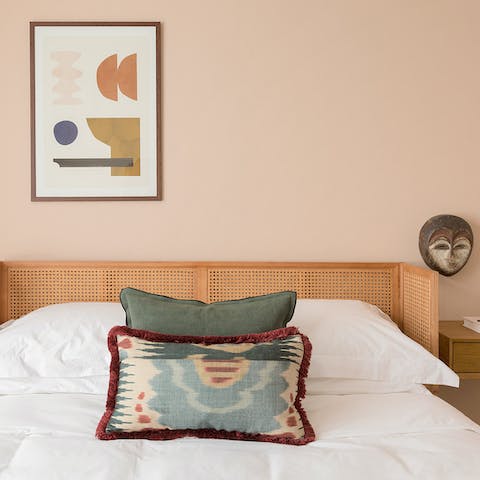 Admire the soft palette and ethnic influence in the bedroom