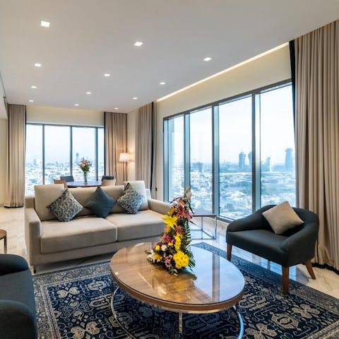 Relax in the living room filled with natural light from walls of glass