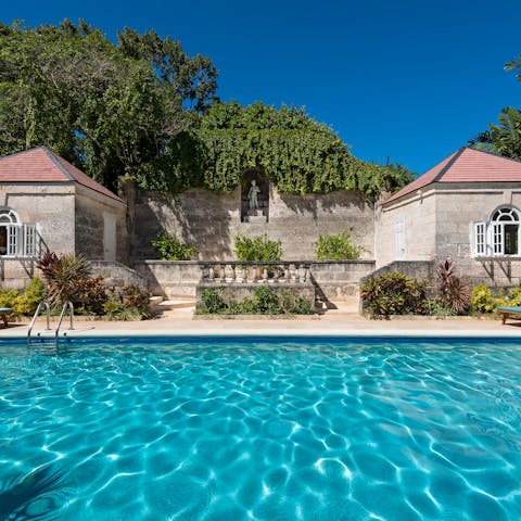 Lounge by the glittering pool surrounded by classic Barbadian architecture