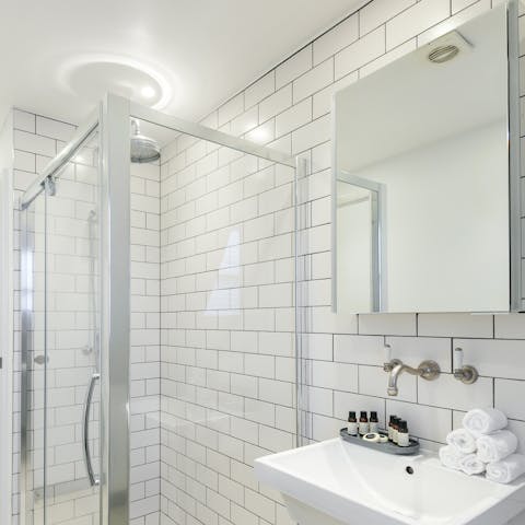 Start mornings with a luxurious soak under the metro-tiled bathroom's rainfall shower