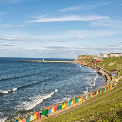 Enjoy coastal strolls past the colourful beach huts that line Whitby Beach