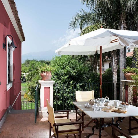 Enjoy alfresco meals in the sunshine with a view of Mount Etna