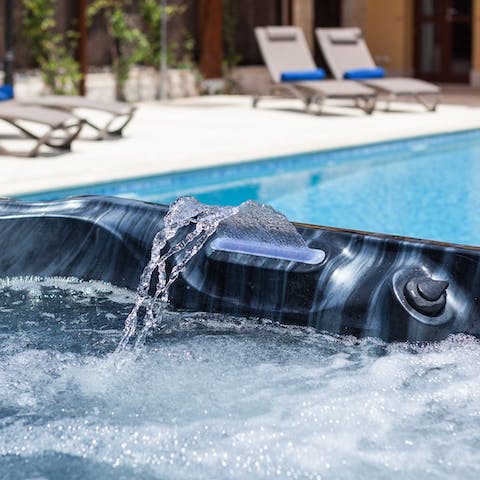 Unwind with a drink in the bubbling hot tub by the pool as your day comes to a close and the sun sets