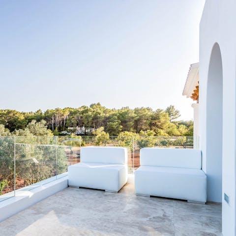 Overlook the lush greenery of Ibiza from your sleek balcony 