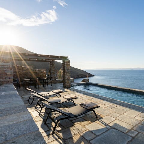 Lie back on a sun lounger and watch the rolling waves of the Aegean Sea