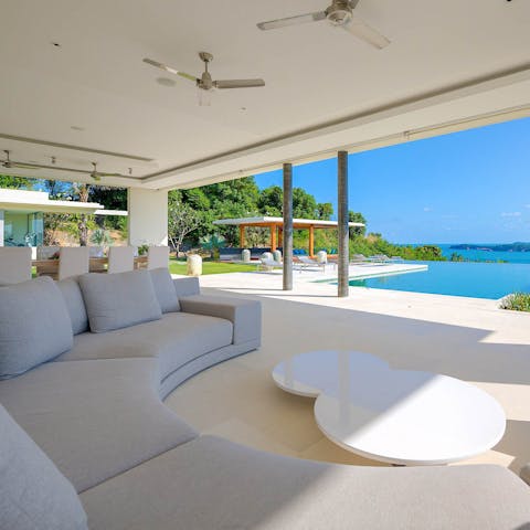 Take in the views across the pool to the sea from the living room's curvy sofa