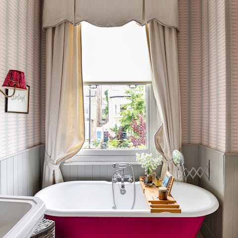 Treat yourself to a well-earned soak in the fetching red bathtub