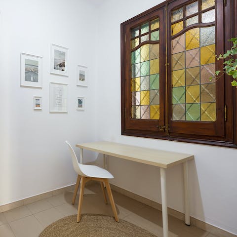 Catch up on work at the desk positioned beneath a stained glass window