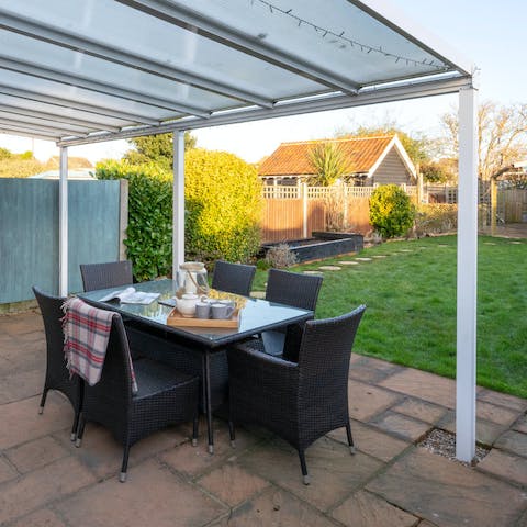 Eat together on the covered patio while the kids play on the lawn