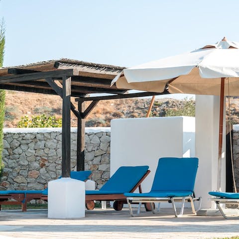 Spend hot afternoons relaxing on a lounger under the shaded pergola