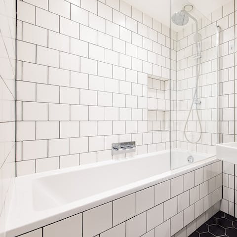 Enjoy a soak in the stylish tiled bathtub after a day of exploring Central London
