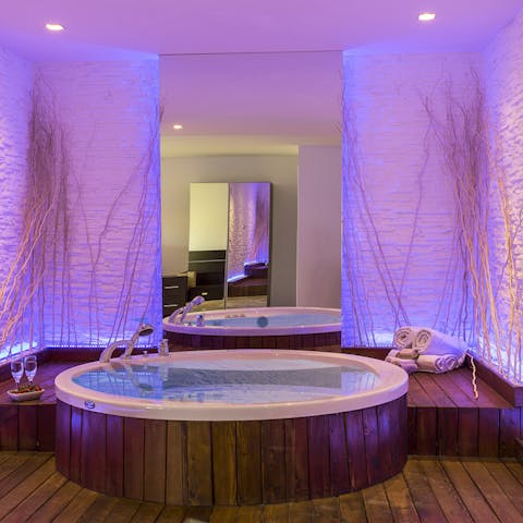 Feel like royalty in this luxurious freestanding jacuzzi with soft purple lighting