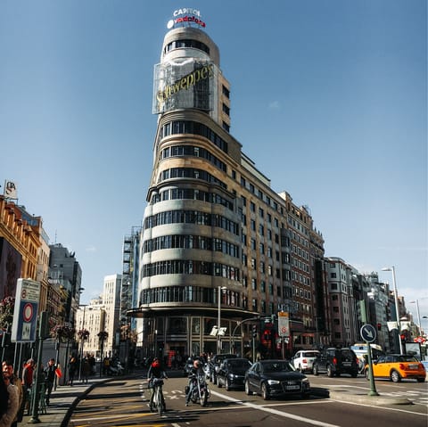 Admire Gran Vía's striking architecture and myriad shops, a seventeen-minute walk away
