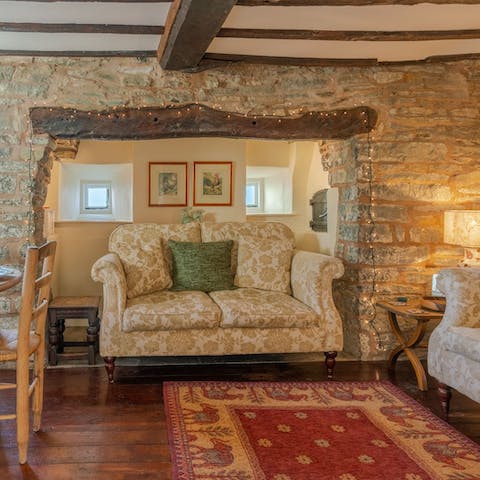 Get comfortable on the floral sofa in the alcove,  among exposed brickwork and original beams