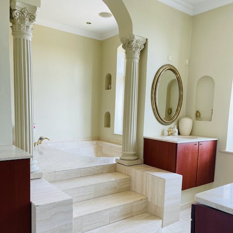 Unwind in the sumptuous bath through the bathroom archway