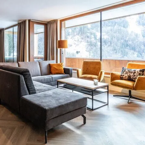 Enjoy panoramic snowy, mountain views from floor to ceiling windows in the living room