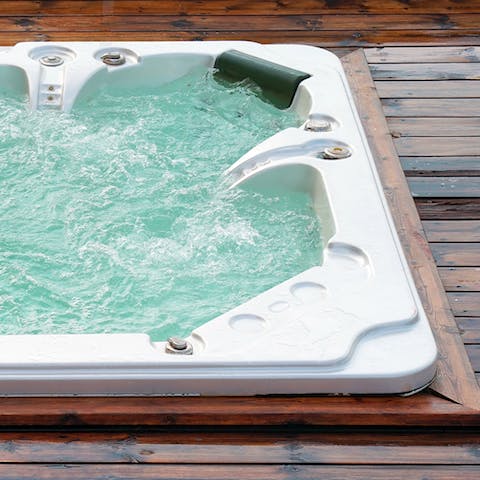 Relax with a glass of champagne in the hot tub surrounded by the lush grounds