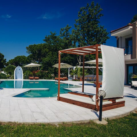 Soak up the sun from the daybed beside the private pool