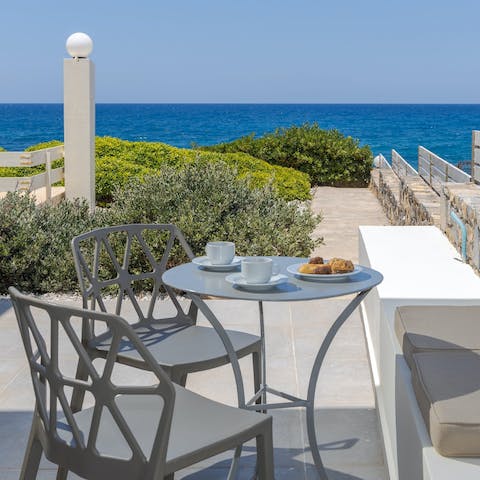Enjoy a morning coffee on the private terrace overlooking the Aegean Sea