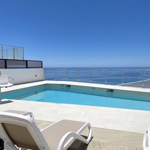 Lounge by the pool with a stunning view of the ocean, and go for a dip in the calm blue waters