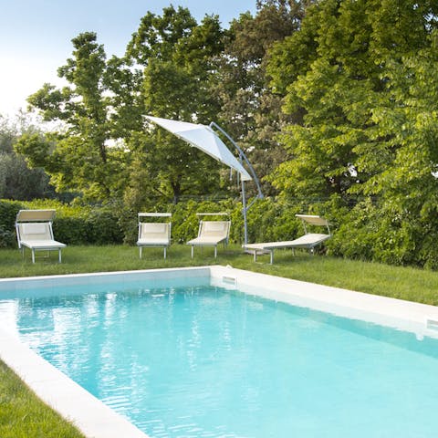 Enjoy sunny afternoons by the pool, surrounded by the verdant greenery of the villa gardens